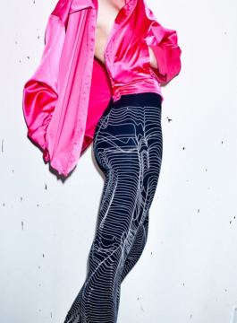 Photography. Fashion editorial. Model wearing a pink silk jacket nd a black all over printed leggings. All over white screen print on black leggings by Lick my legs-Paris 