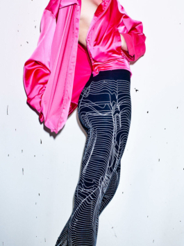 Photography. Fashion editorial. Model wearing a pink silk jacket nd a black all over printed leggings. All over white screen print on black leggings by Lick my legs-Paris 