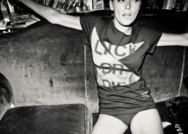 photography. Model in panties wearing a black t-shirt on a sofa. 