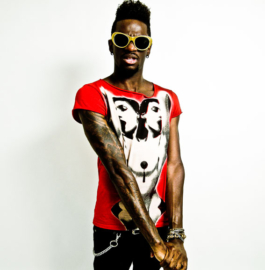 Photographe. Fashion editorial. Black model wearing sunglasses and red printed t-shirt 