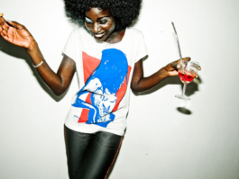 Photography. Nightclub. Woman laughing with a glass of Martini in her hand. 