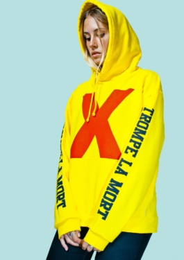 Photography. Fashion editorial. Model wears a yellow Hoodie with X print on front. 